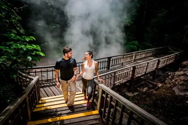 Couple walking across a bridge in a Costa Rica jungle
