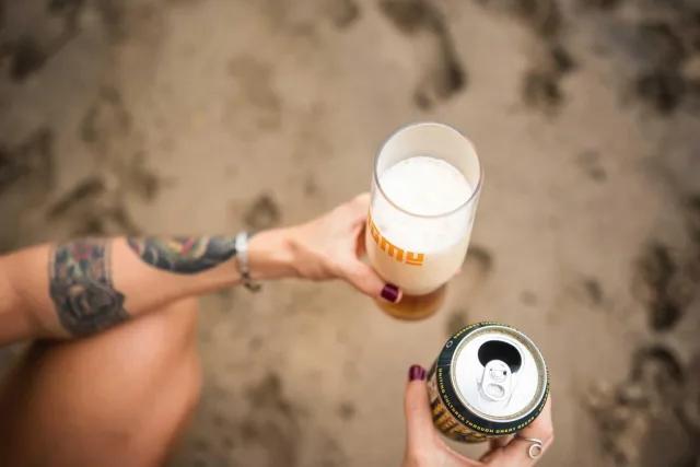 Person having craft beer at the beach