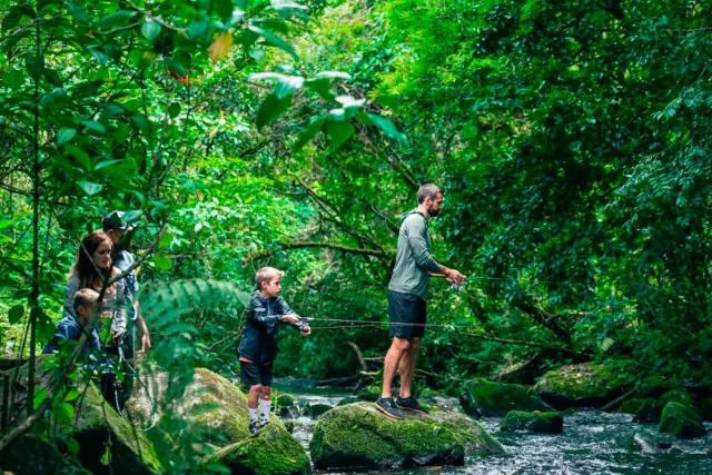 Family fishing together in a river in the mountains