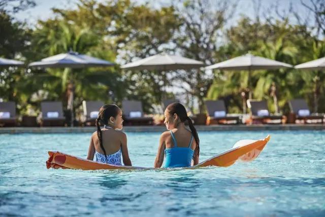 Two children talking on a resort pool in Costa Rica