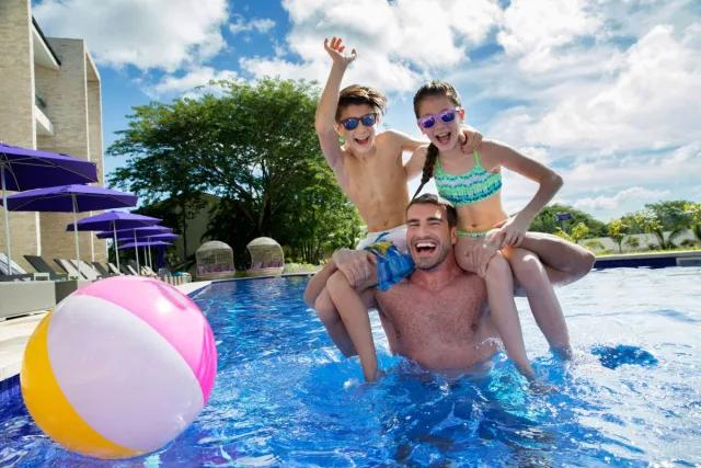 Father and children enjoying family pool at Planet Hollywood, Papagayo