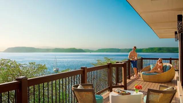 Couple in the balcony of their hotel room overlooking the Pacific Ocean