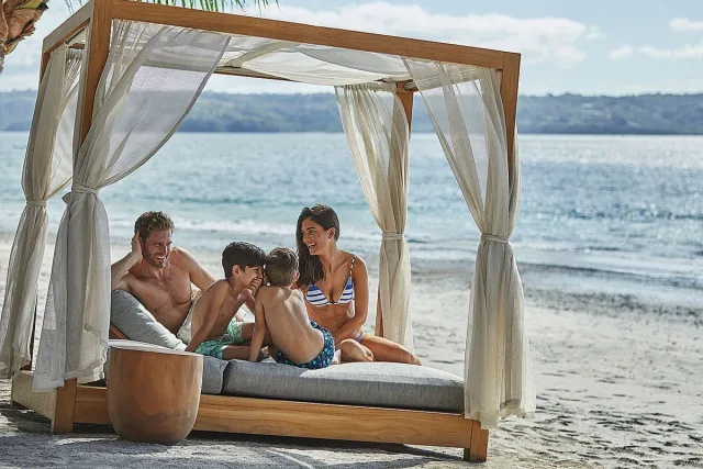 Parents and children enjoying a beach bed at Four Seasons Papagayo